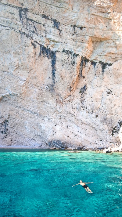 The people on the floating in the rock near water
